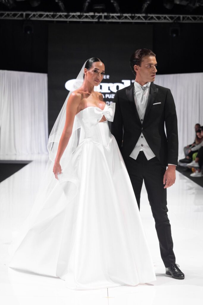 Abito da sposa con fiocco e tight da sposo, sfilata Atelier Carol