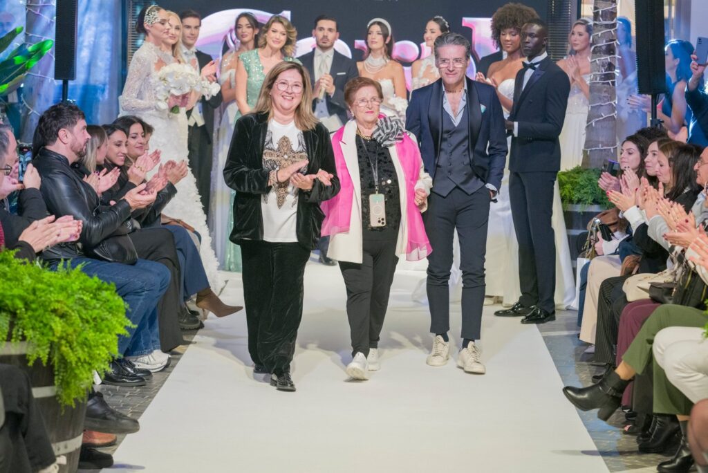 Carolina Puzio in passerella tra gli applausi alla fine della sfilata Atelier Carol nel cortile